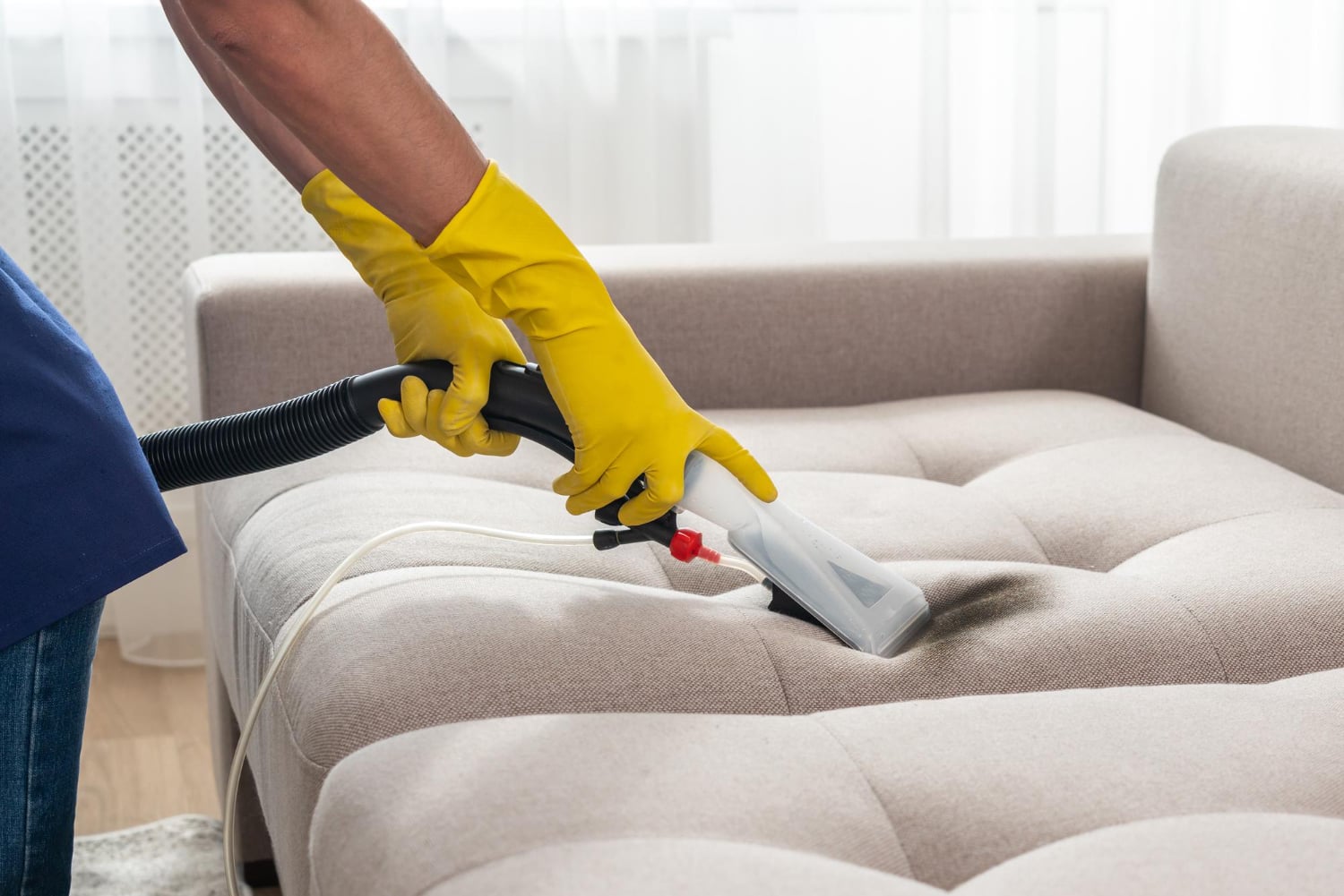 Schoonmaker reinigt een bank met stoomreiniger